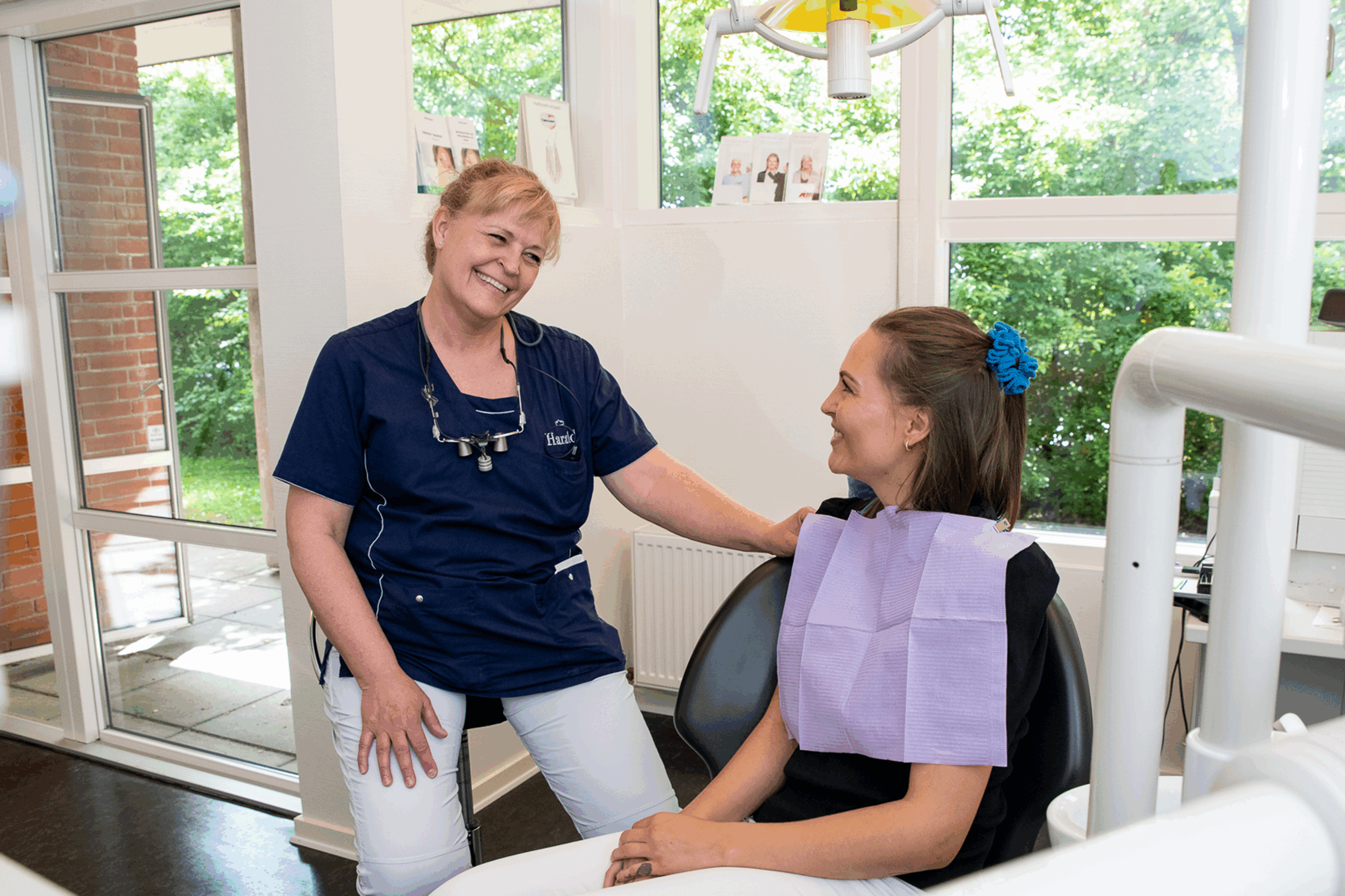 Patient og tandplejer der snakker omhyggeligt sammen.